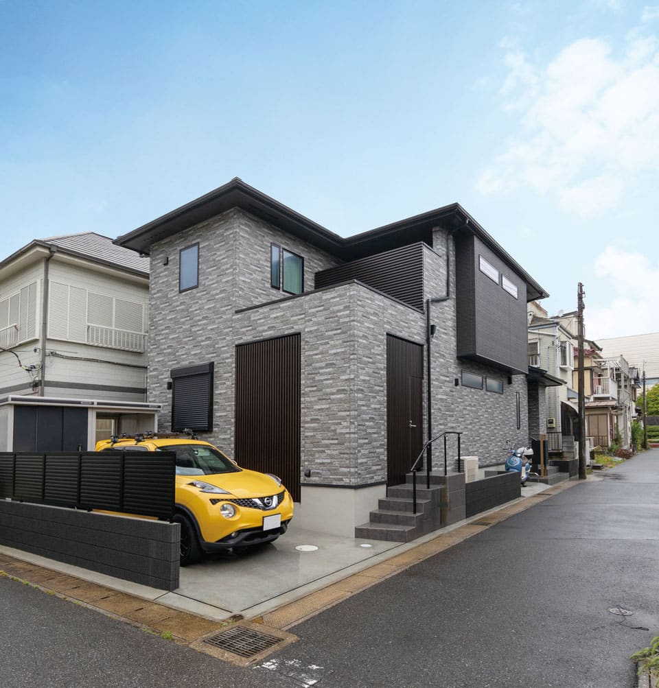 敷地に合わせた間口が広い建物を、外壁で変化をつけて立体感のある外観に