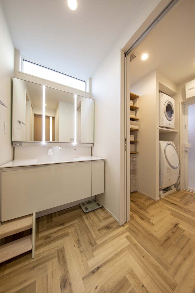 ヘリンボーンの床が印象的な分離型洗面脱衣室。