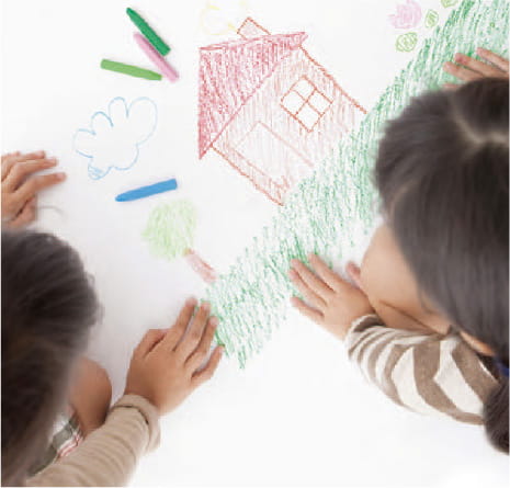 子供が家の絵を書いてる写真