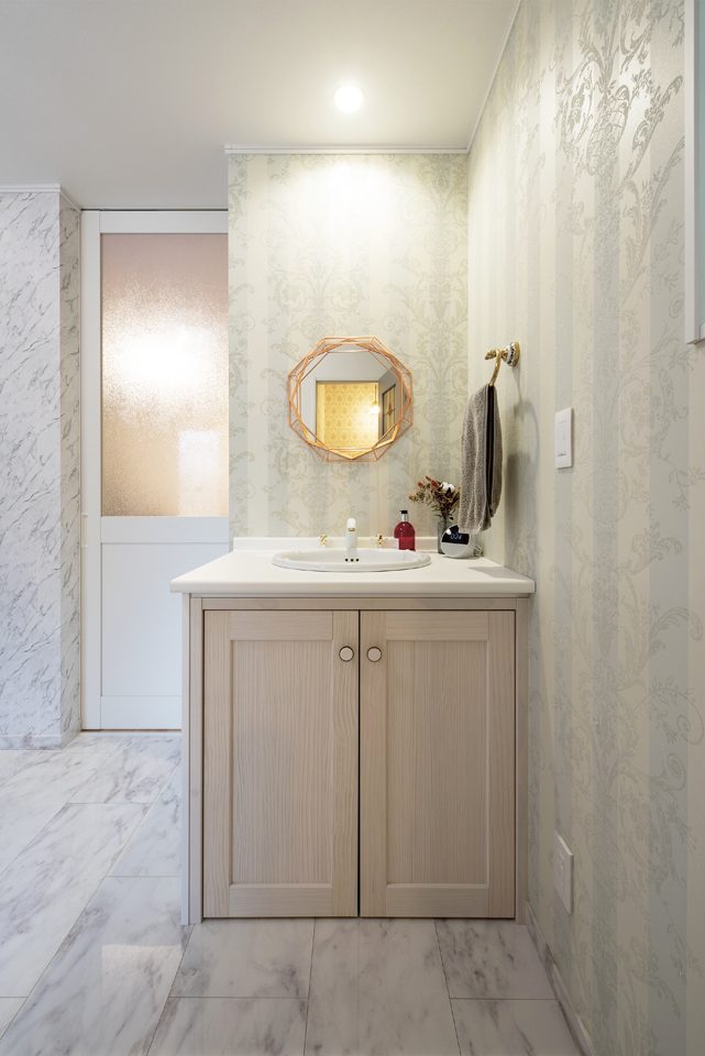 繊細な壁紙にゴールドが煌めく、ホテルライクな淡色サニタリー